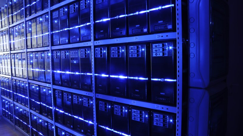 Data center corridor with server cabinets stretching into the distance