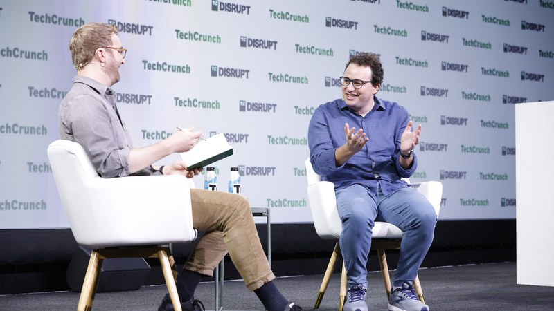 Dario Amodei speaking at TechCrunch Disrupt 2023 — the siblings' opposite backgrounds built one company