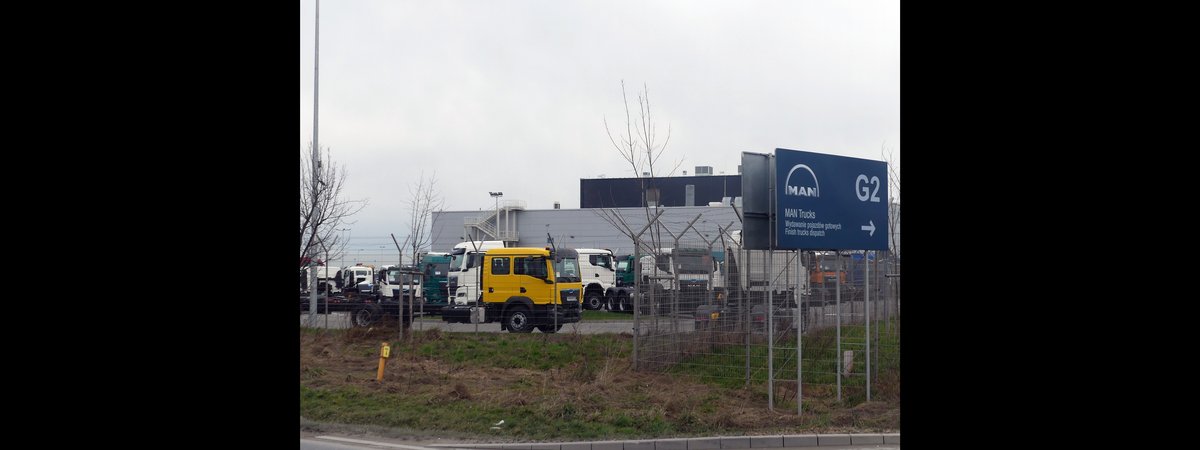 New commercial trucks lined up at a factory dispatch yard