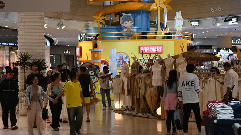 A brightly lit mall retail pop-up with clothing racks — SKIMS grew from online shapewear to 19 physical stores